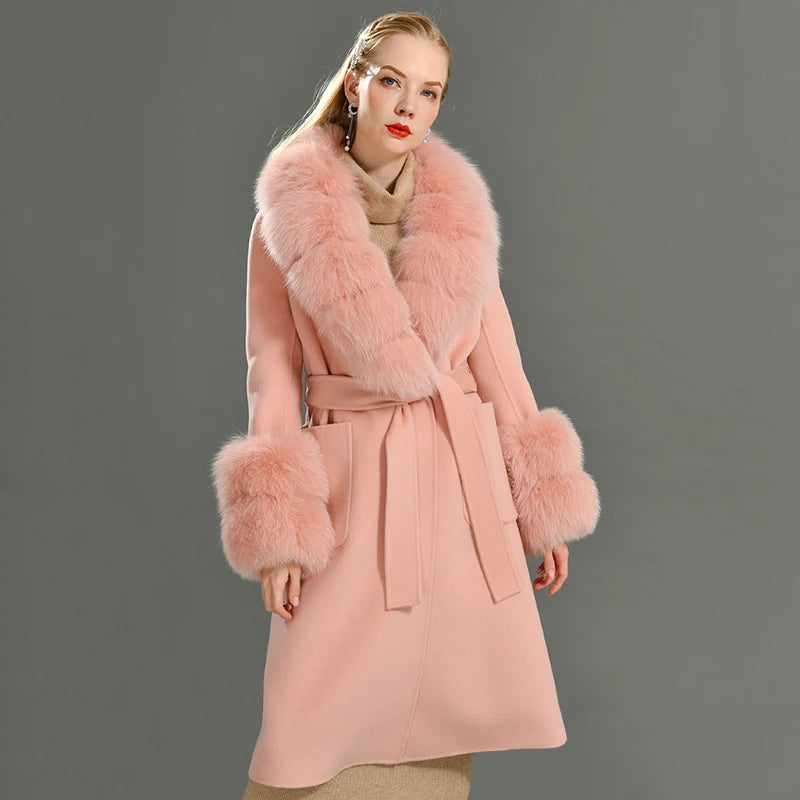 Pink coat with fur trim worn by a model on a gray background