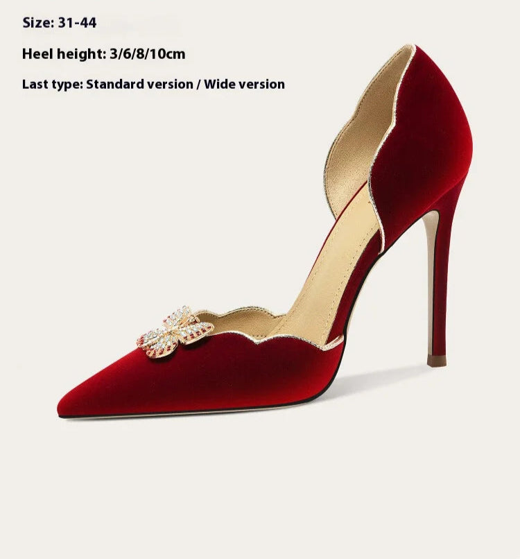 Red high-heeled shoe with gold embellishment on a white background,