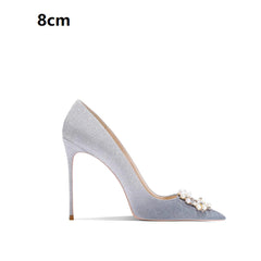 High-heeled shoe with pearl embellishments on a white background