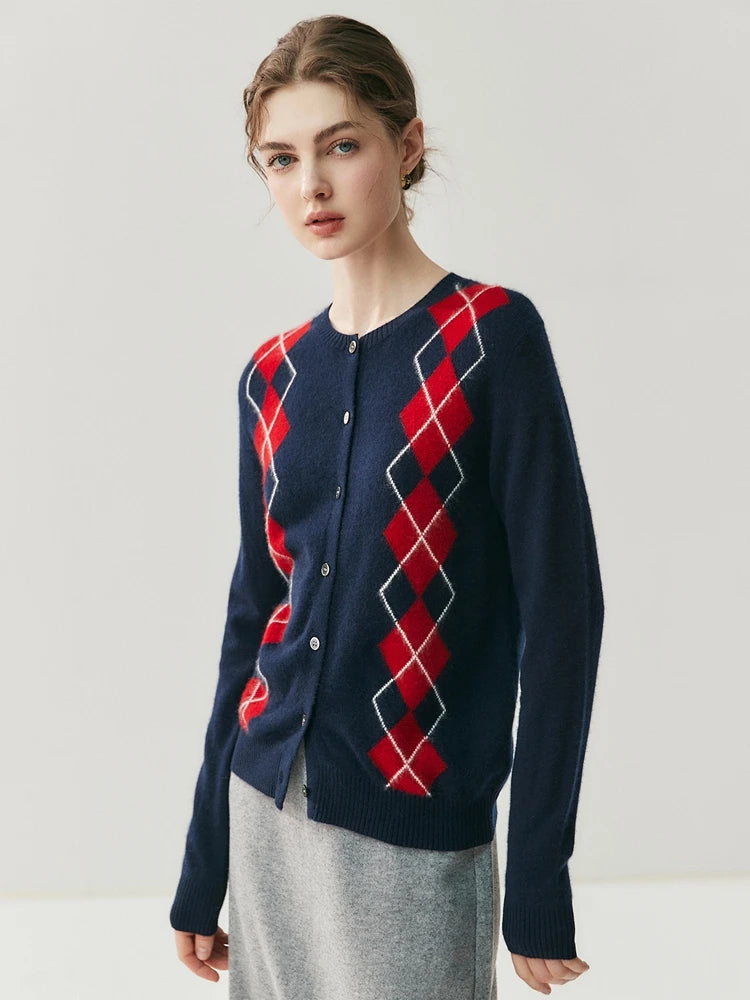 Person wearing a navy blue cardigan with red diamond pattern on a light gray background