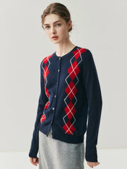 Person wearing a navy blue cardigan with red diamond pattern on a light gray background