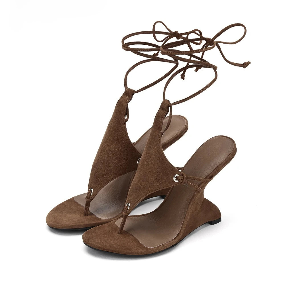 Brown suede sandals with lace-up design on a white background
