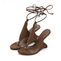 Brown suede sandals with lace-up design on a white background