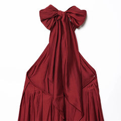 Red evening gown with a large bow on a white background
