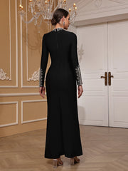 Woman wearing a black evening gown with silver embellishments in an elegant room.