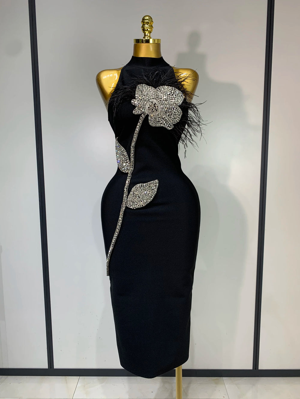 Turtleneck sleeveless diamond and feather embellished midi dress front view.