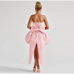 Pink strapless dress with a large bow detail on a white background