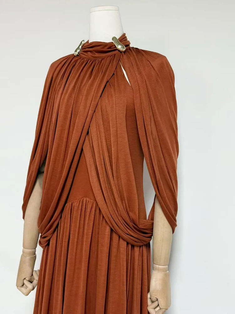 Brown draped dress on a mannequin against a white background