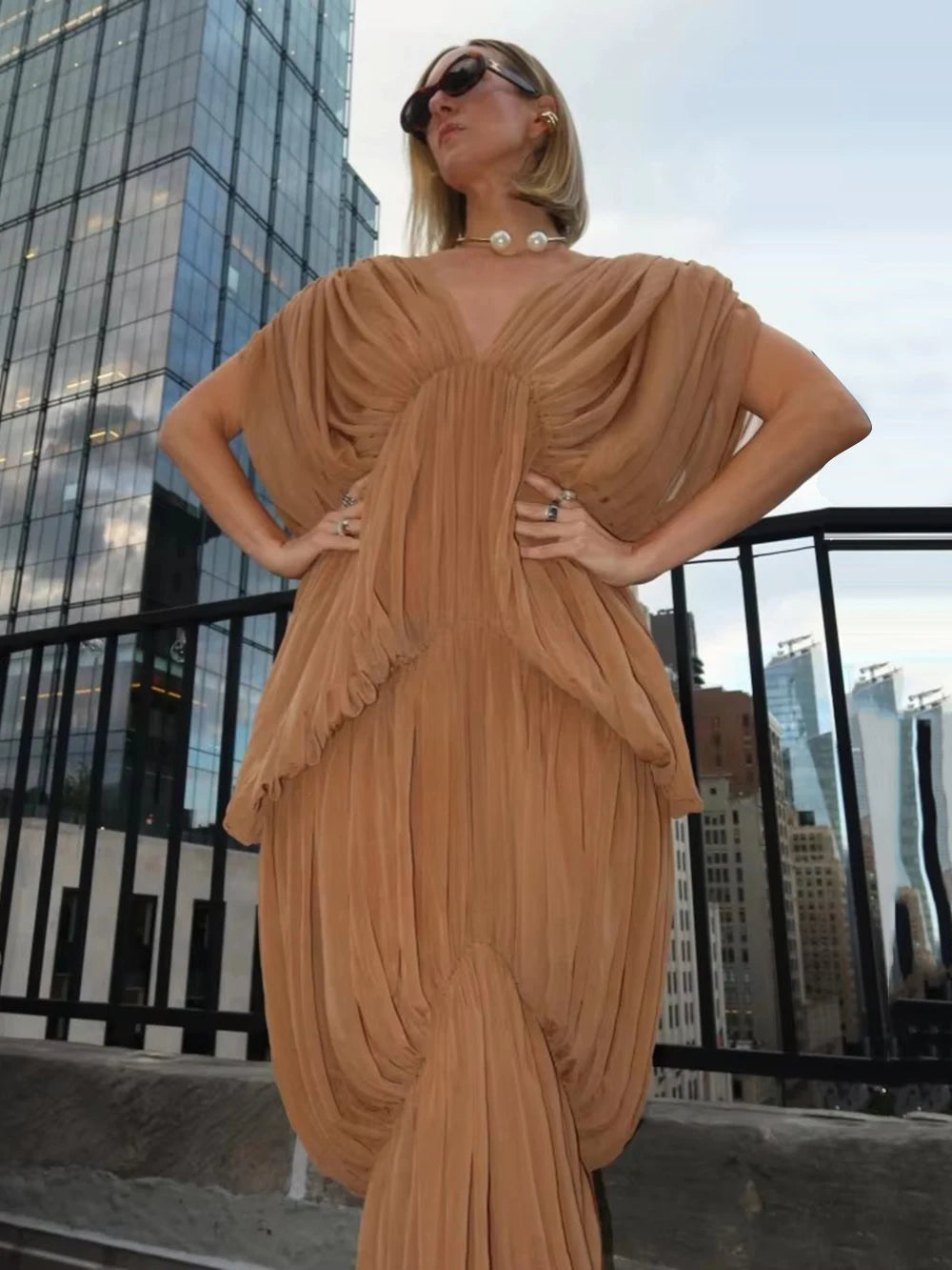 Close-up of gauze drape v-neck dress on model with city skyline