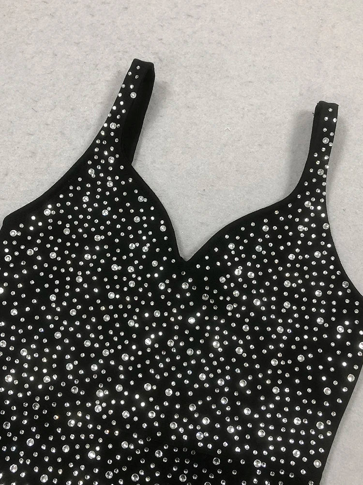 Black strappy top with silver embellishments on a light gray background