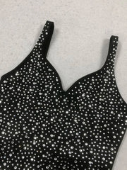 Black strappy top with silver embellishments on a light gray background