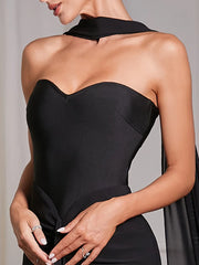Black strapless dress worn by a model against a neutral background