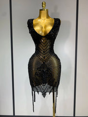Black beaded dress on a mannequin against a plain background