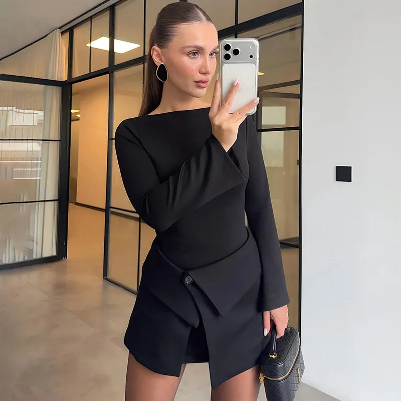 Woman taking a mirror selfie wearing a black outfit in an indoor setting.