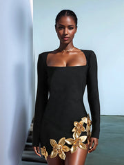 Woman wearing a black dress with gold floral details against a light blue background