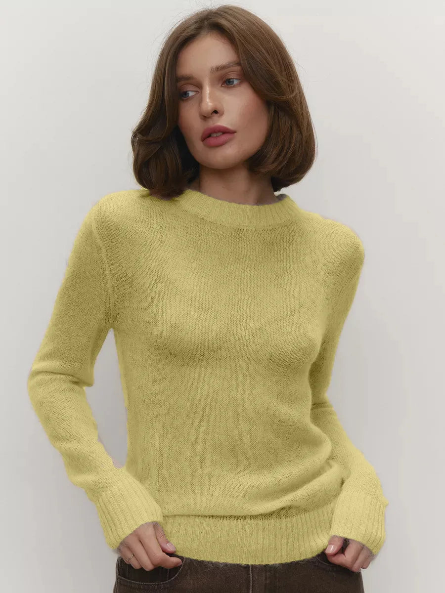 Woman wearing a light green sweater against a plain background