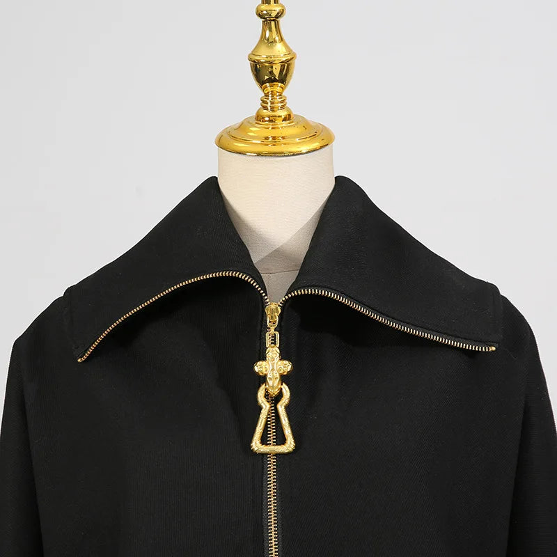 Black coat with gold zipper and decorative pull on a mannequin against a gray background