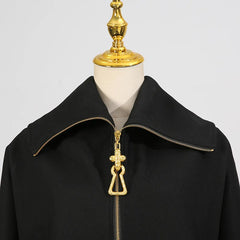 Black coat with gold zipper and decorative pull on a mannequin against a gray background