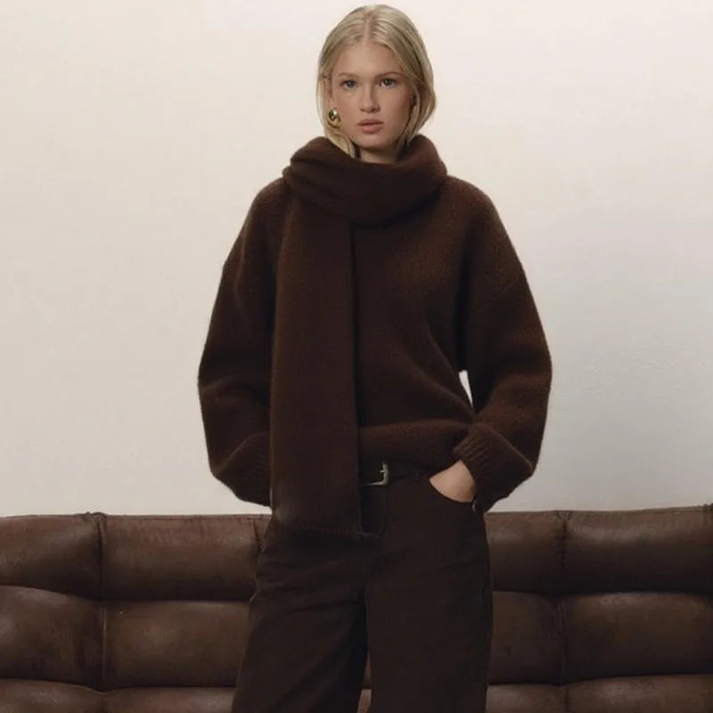 Person wearing a brown sweater and pants standing in front of a brown sofa.