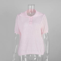 Pink knitted top on a mannequin against a gray background