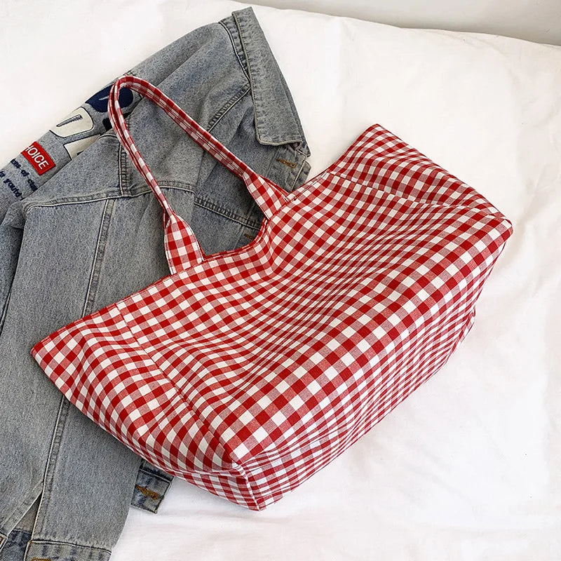 Red and white checkered bag on a light gray jacket with a white background