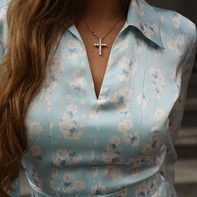 Light blue floral blouse worn by a person with a blurred background