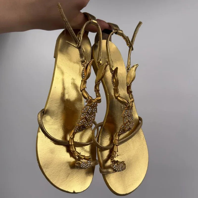 Close-up of gold stiletto heel with scorpion embellishment detail