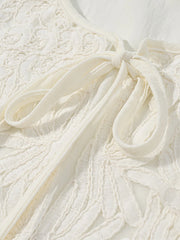 Close-up of a textured white fabric with a bow