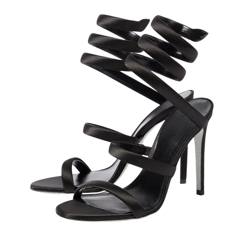 Black strappy high-heeled sandals on a white background