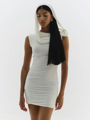 Woman wearing a white dress with a matching headscarf on a white background