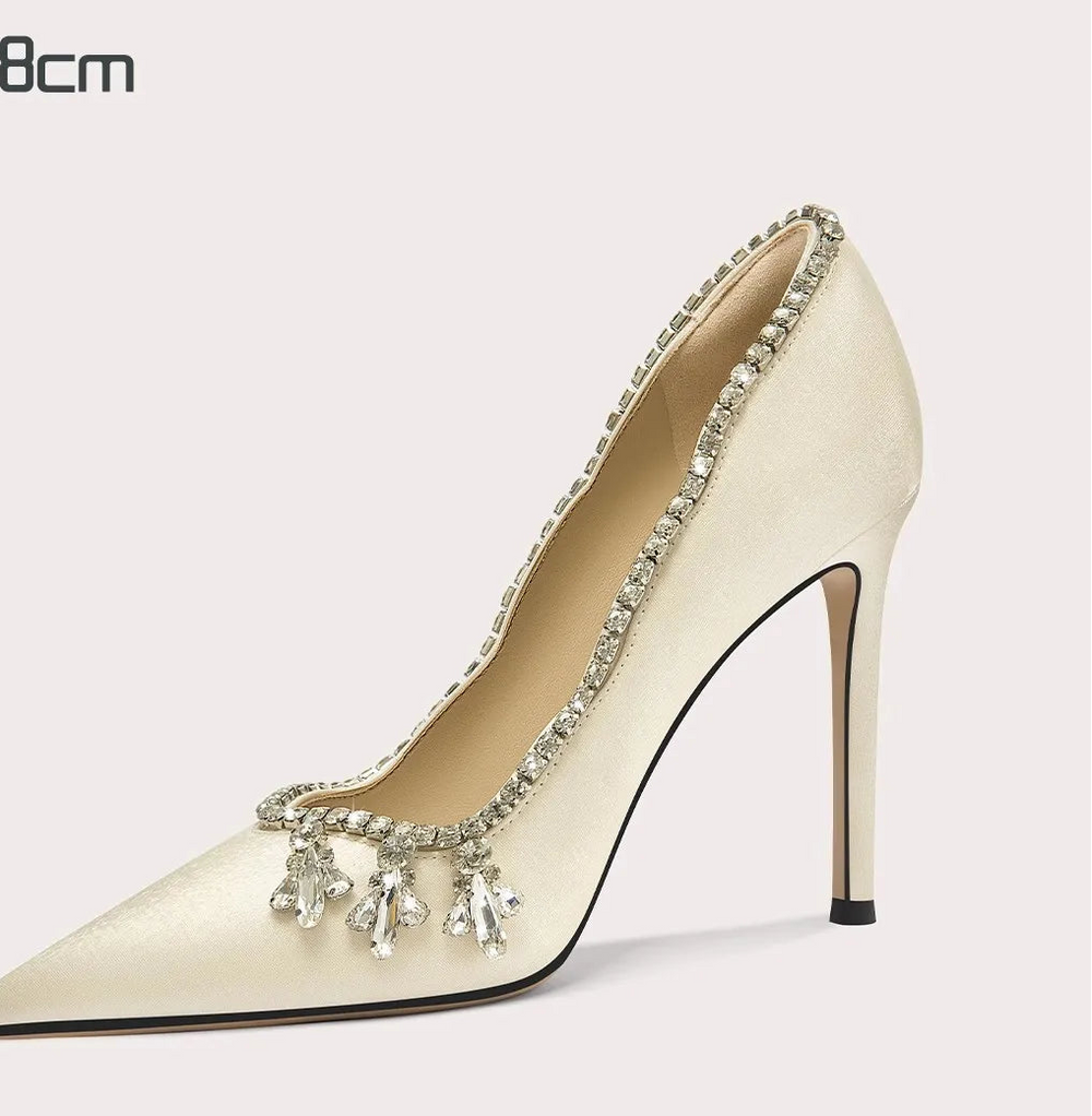 High-heeled shoe with embellishments on a light gray background