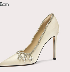 High-heeled shoe with embellishments on a light gray background