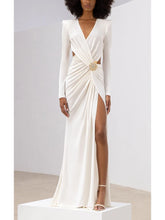 White evening gown with long sleeves and a high slit on a white background