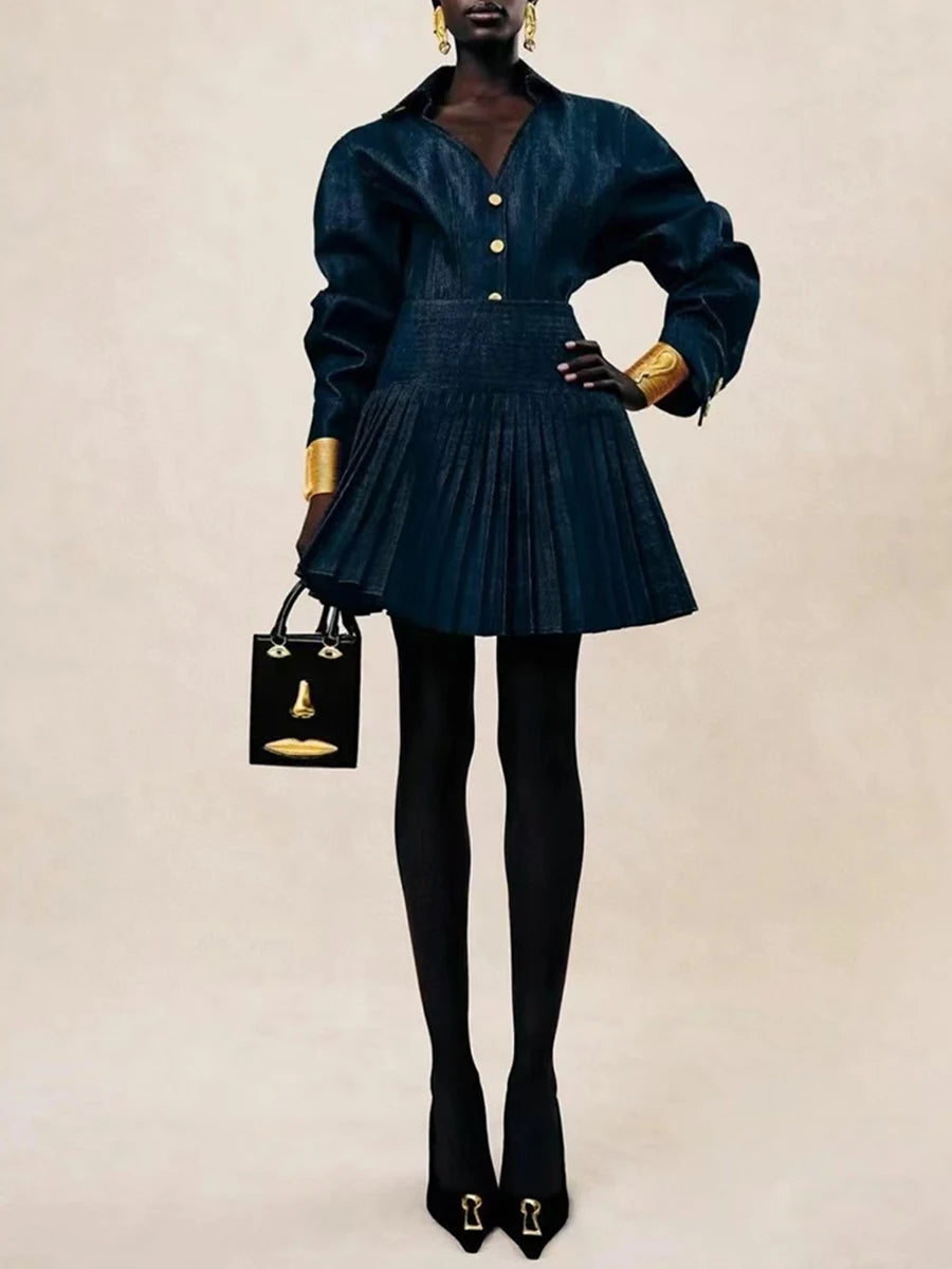 Person wearing a dark blue outfit with gold accents, holding a matching handbag on a beige background