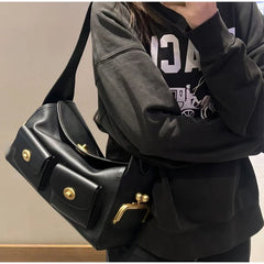 Person wearing a black hoodie and a black PU leather shoulder bag with a lock detail.