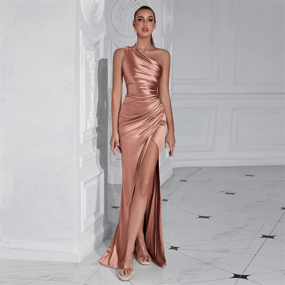 Woman wearing a one-shoulder rose gold gown in an elegant interior setting
