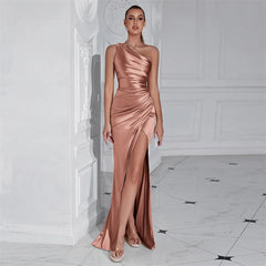 Woman wearing a one-shoulder rose gold gown in an elegant interior setting