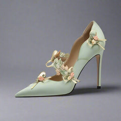 Green high-heeled shoe with floral decorations on a white background