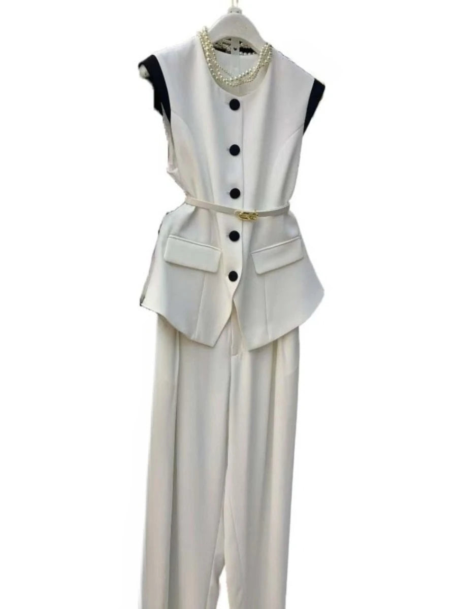 White sleeveless top with black buttons and matching pants on a white background