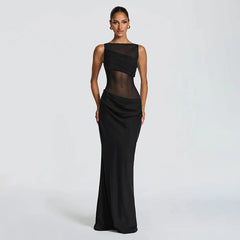 Woman wearing a black evening gown with sheer top on a white background