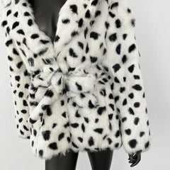 White fur coat with black spots on a plain background