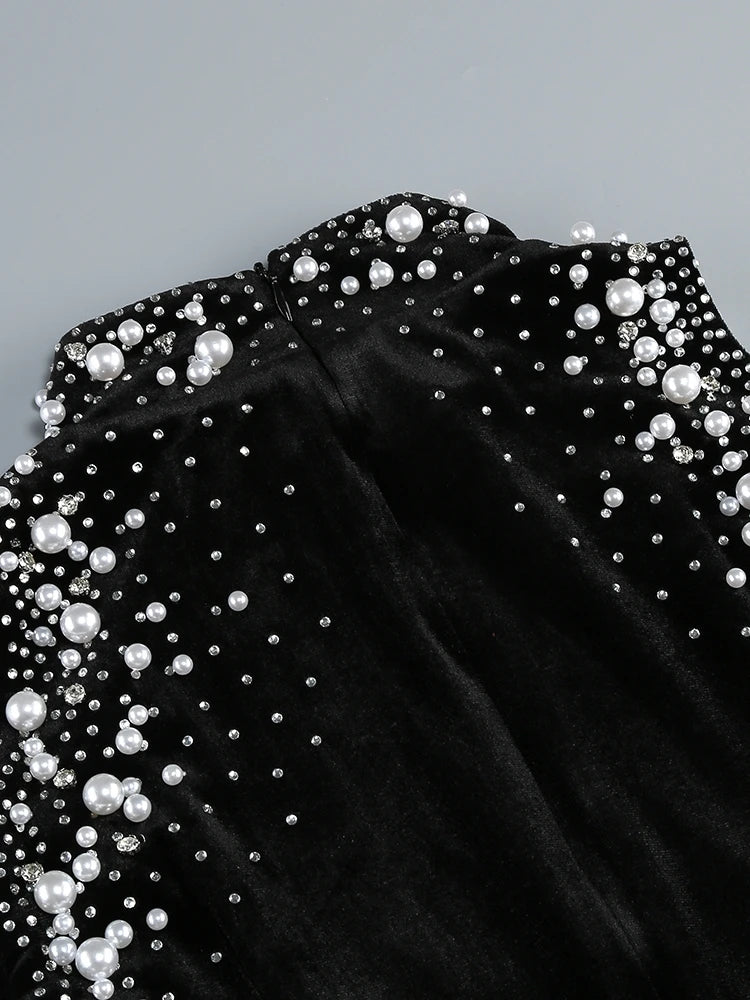 Black off-shoulder top with pearl embellishments on a gray background