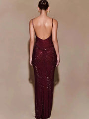 Woman wearing a burgundy evening gown with a low back on a beige background