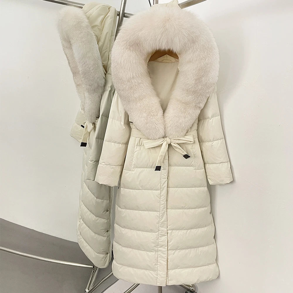 White puffer coat with fur collar on a rack against a white background