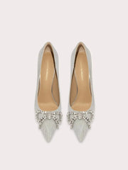 Pair of silver pointed-toe shoes with embellishments on a light gray background