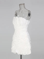White strapless dress on a mannequin against a gray background