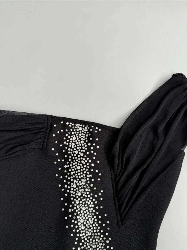 Black garment with white embellishments on a light gray background