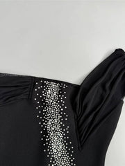 Black garment with white embellishments on a light gray background
