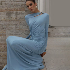 Woman in a light blue dress sitting on stone steps.