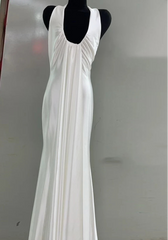 White evening gown on a mannequin against a plain background